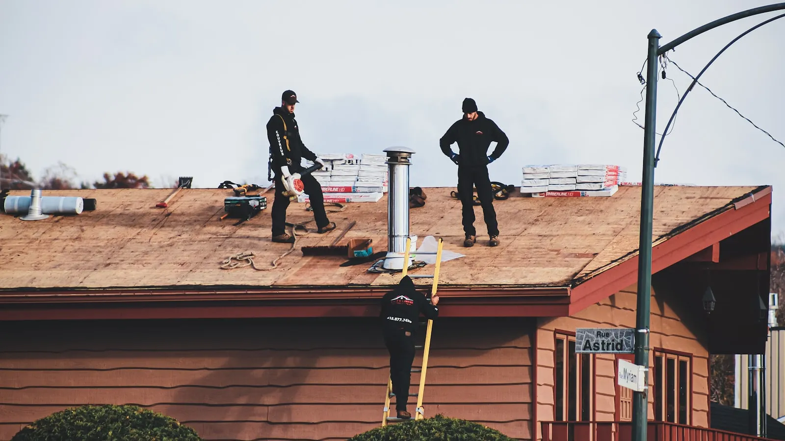 Crew installing new shingles on a residential roof